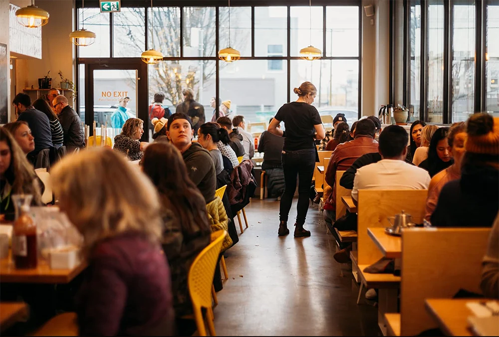 Busy breakfast restaurant dining room representing breakfast franchise cost Canada and growing restaurant investment opportunities
