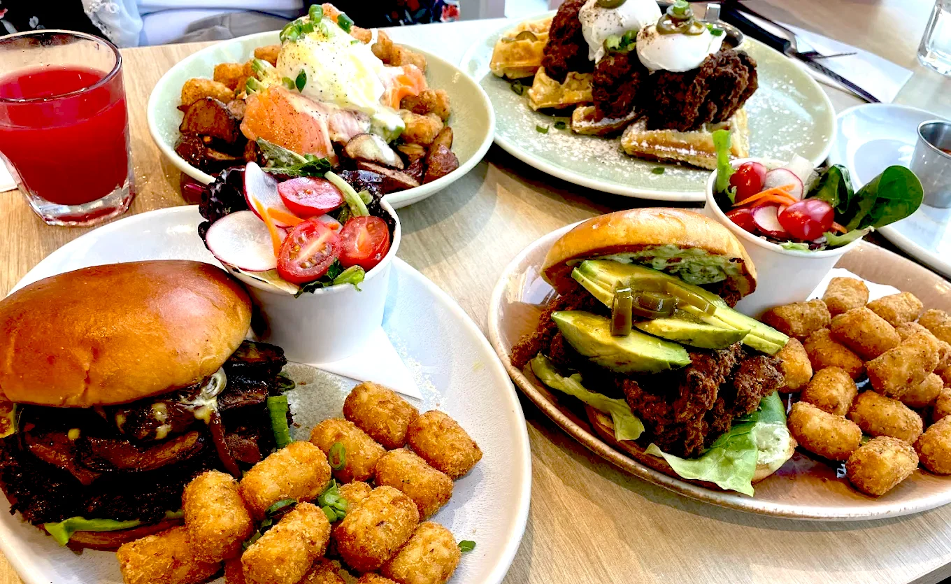 Breakfast and brunch dishes served at Yolks Glebe in Ottawa, including eggs benedict, chicken and waffles, breakfast sandwiches, fresh salads, and tater tots.