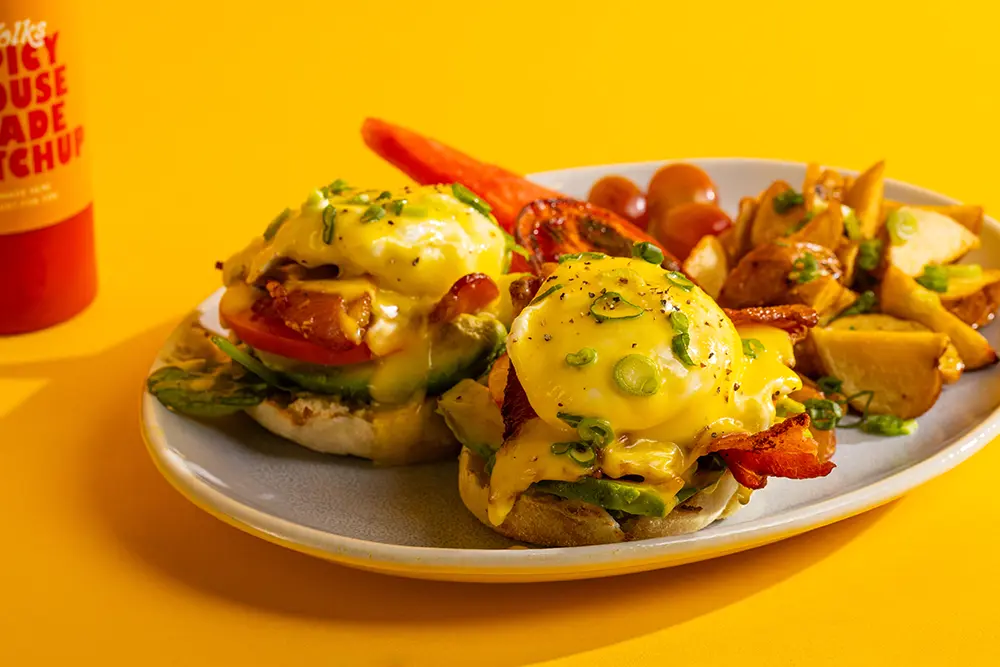 Eggs benedict with avocado, bacon and breakfast potatoes at Yolks in Vancouver